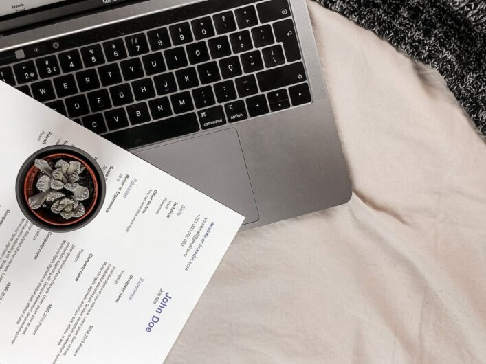 Laptop and resume on a bed