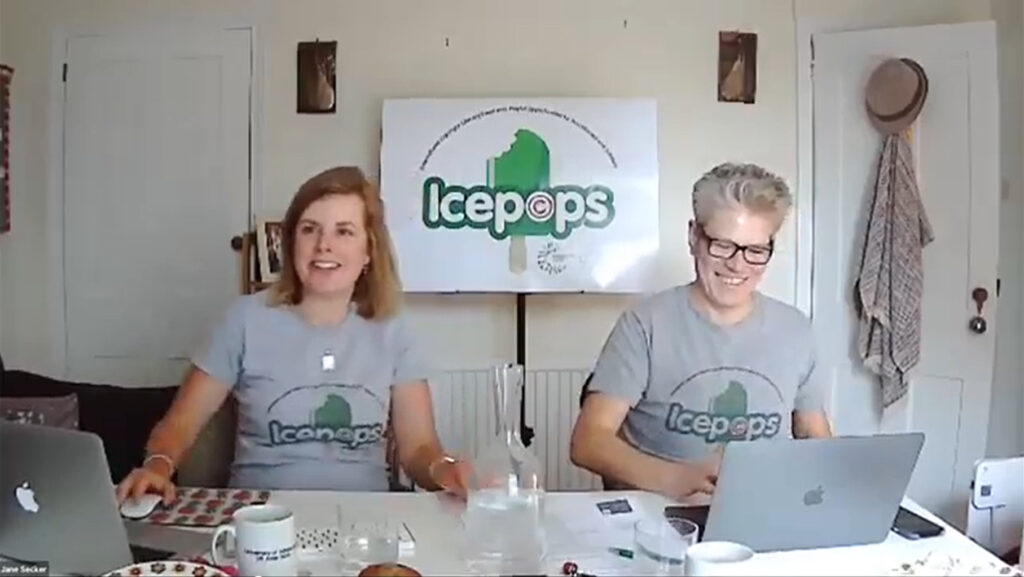 Image of Chris and Jane sitting at desk with laptops, both smiling, having fun delivering Icepops